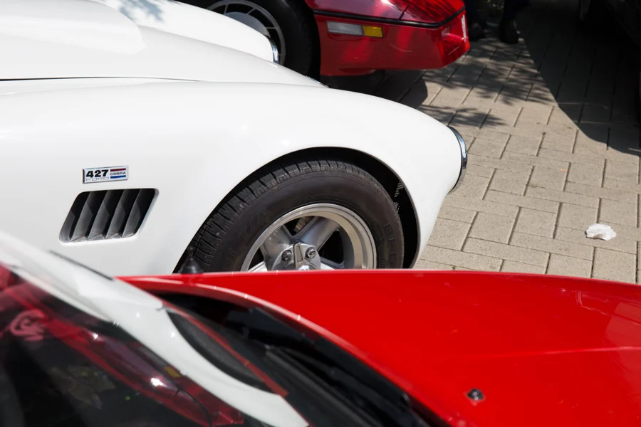 Detail eines weißen Sportwagens zwischen roten Karosserieteilen