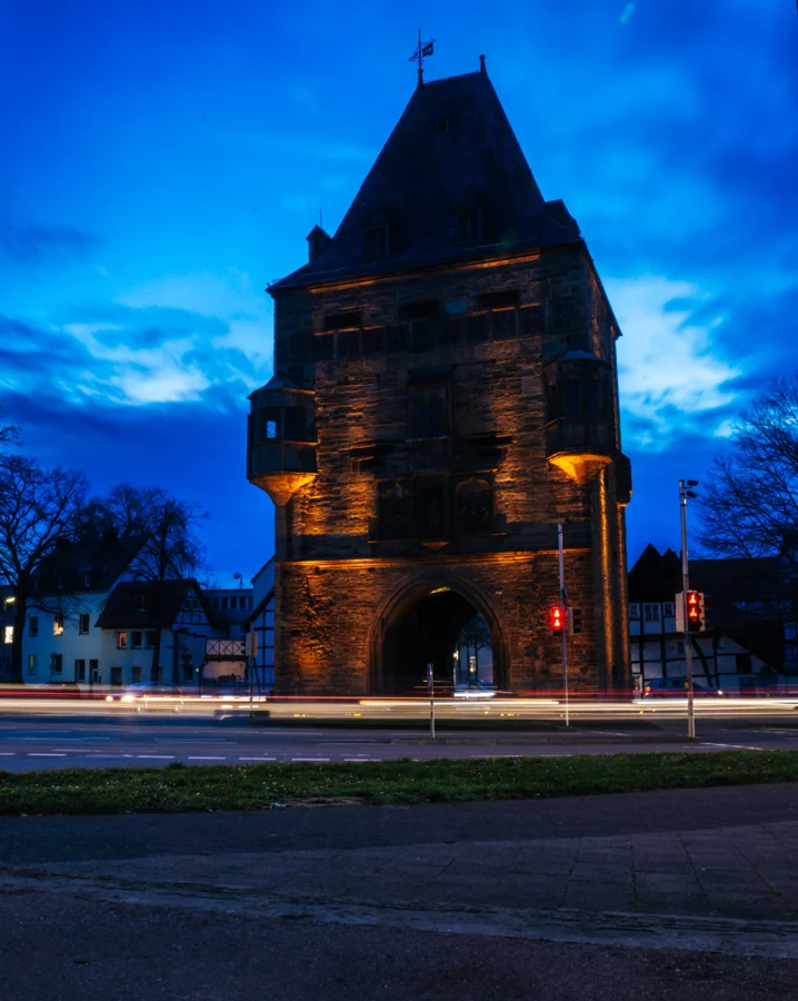 Ein alter steinerner Turm vor einem tiefblauen Abendhimmel