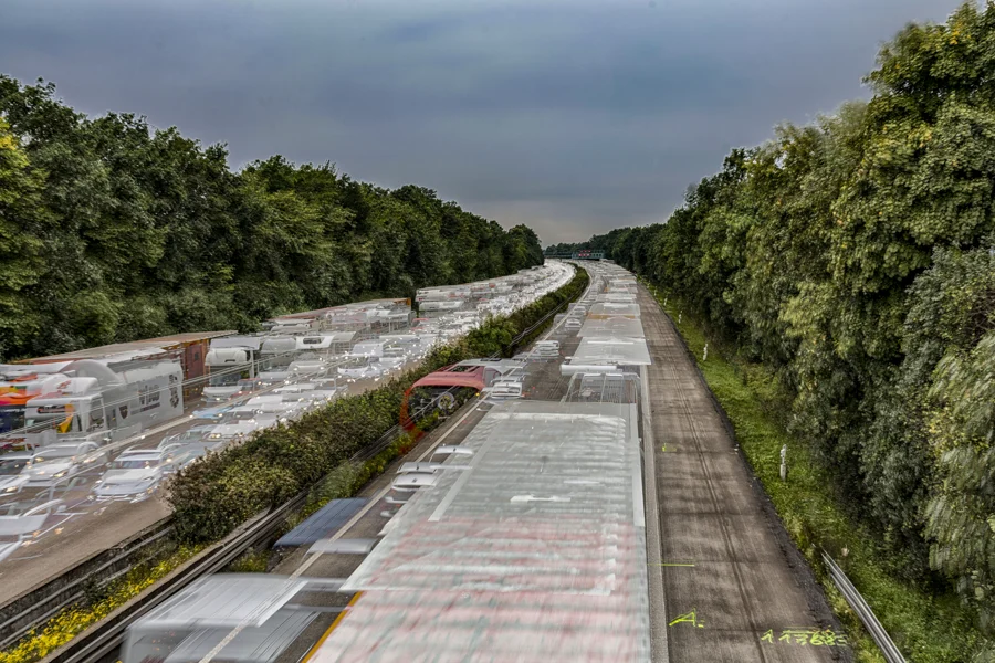 Lange parallele Verkehrswege zwischen grünen Baumreihen