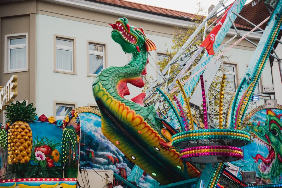 Fahrgeschäfte und historische Gebäude auf der Soester Kirmes