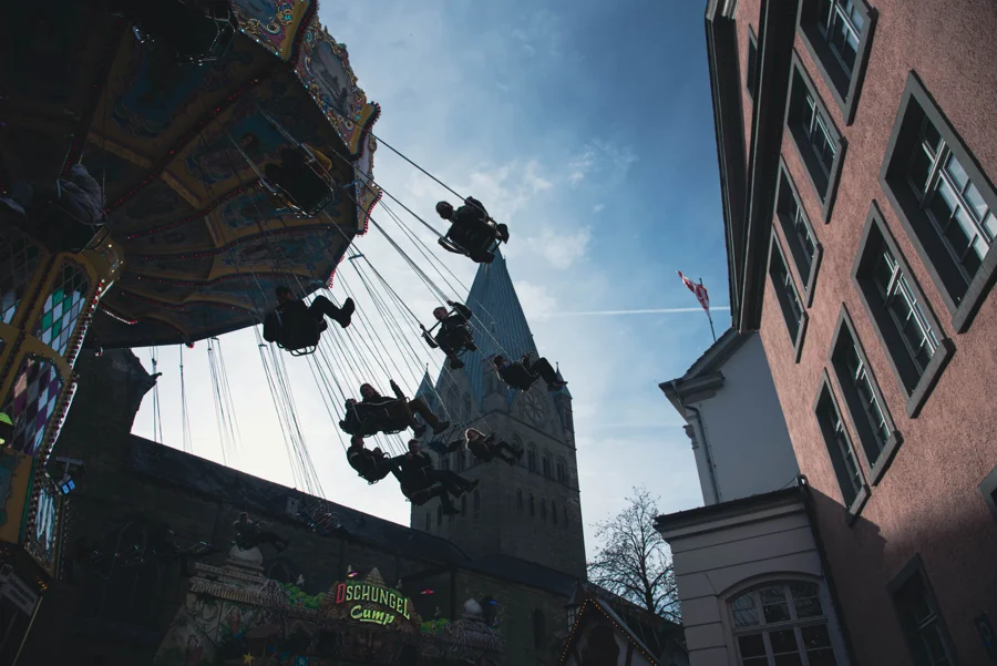 Fahrgeschäfte und historische Gebäude auf der Soester Kirmes