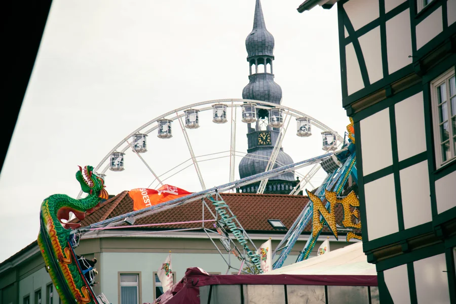 Fahrgeschäfte und historische Gebäude auf der Soester Kirmes