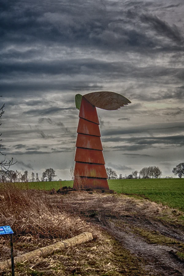 Rote öffentliche Skulptur vor dramatischen Wolken