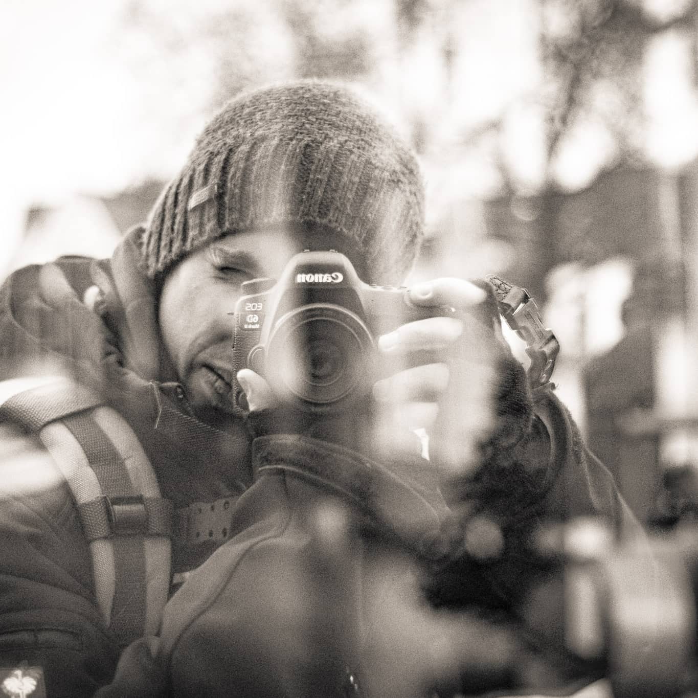 Robin mit Mütze und Kamera, fotografiert in einer Spiegelung